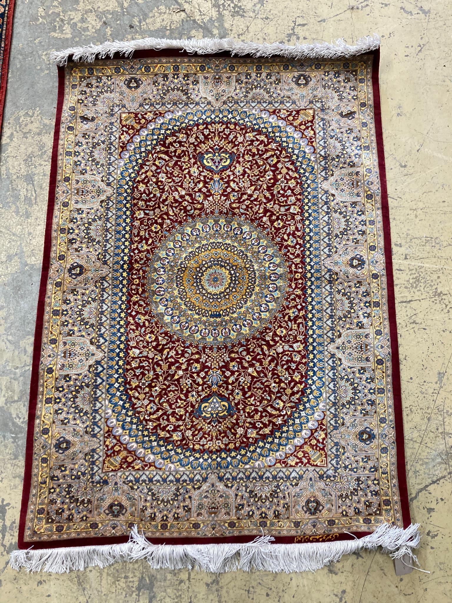 A Persian part red ground silk multi-floral patterned rug, 110 x 80cm